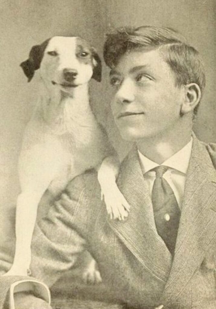 Vintage family photo: a boy posing with his dog