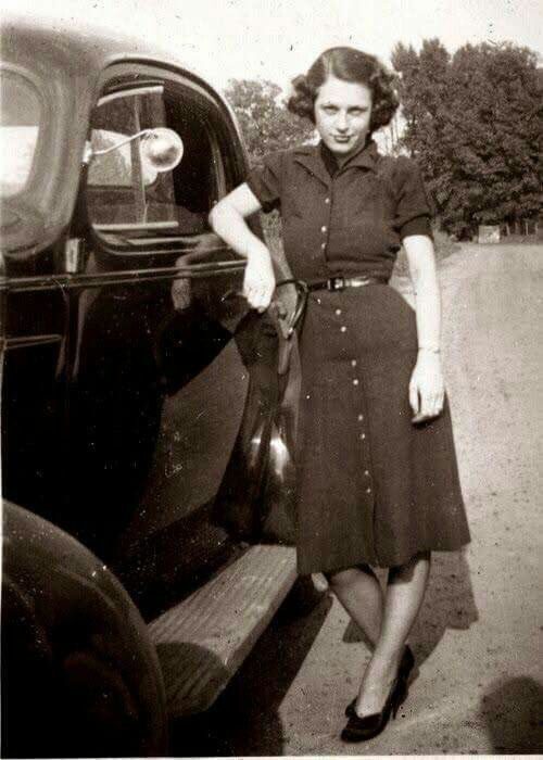 Vintage family photo: a young woman leaning on the family car