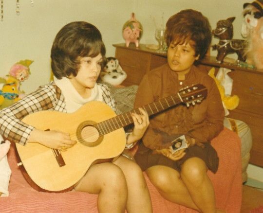 Vintage photo: two young women, one playing guitar, singing together