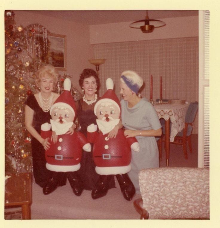 Vintage photo: three women laughing with inflatable Santa decorations