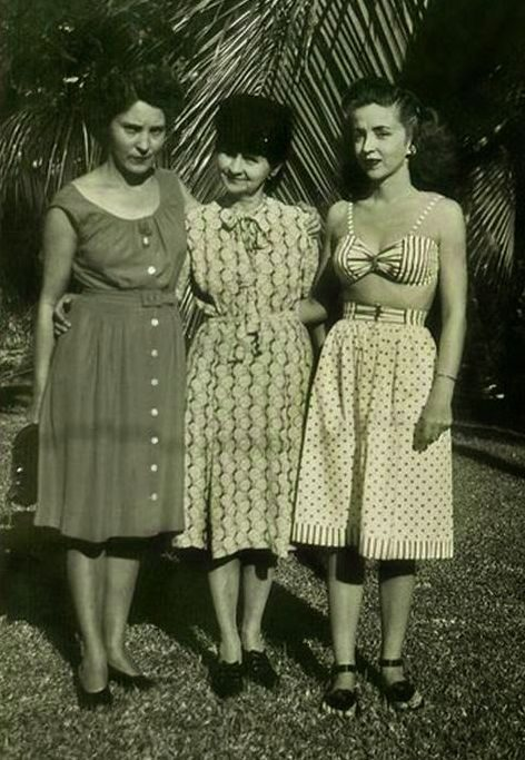 Vintage photo: three women standing together by palm trees