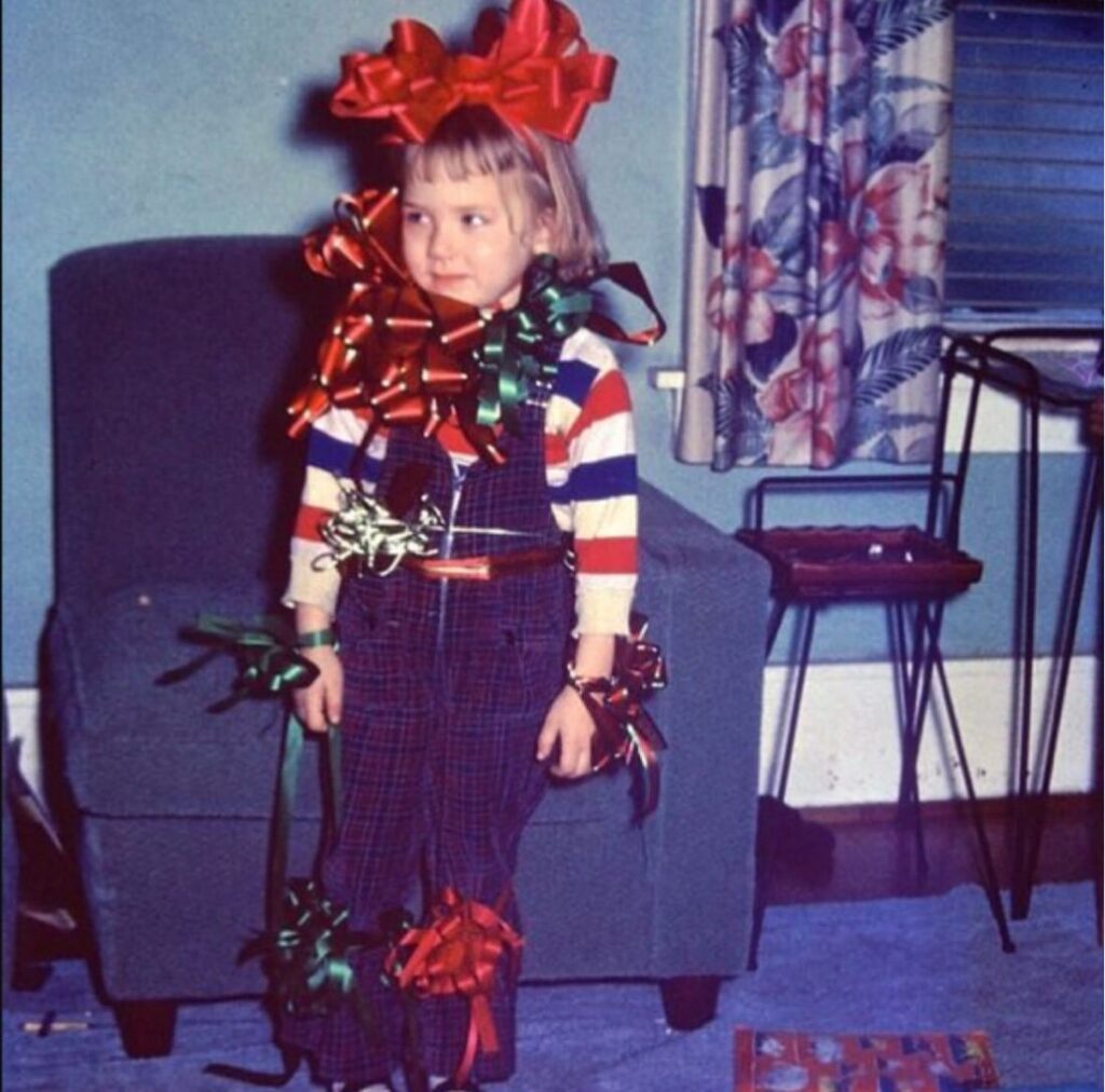 Vintage photo: a child covered in Christmas gift bows