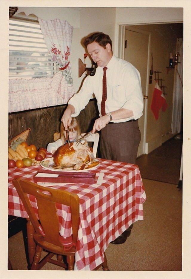 Vintage family photo: a father carving the holiday turkey with his daughter