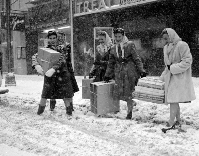 Vintage family photo: women carrying parcels through a snowy street